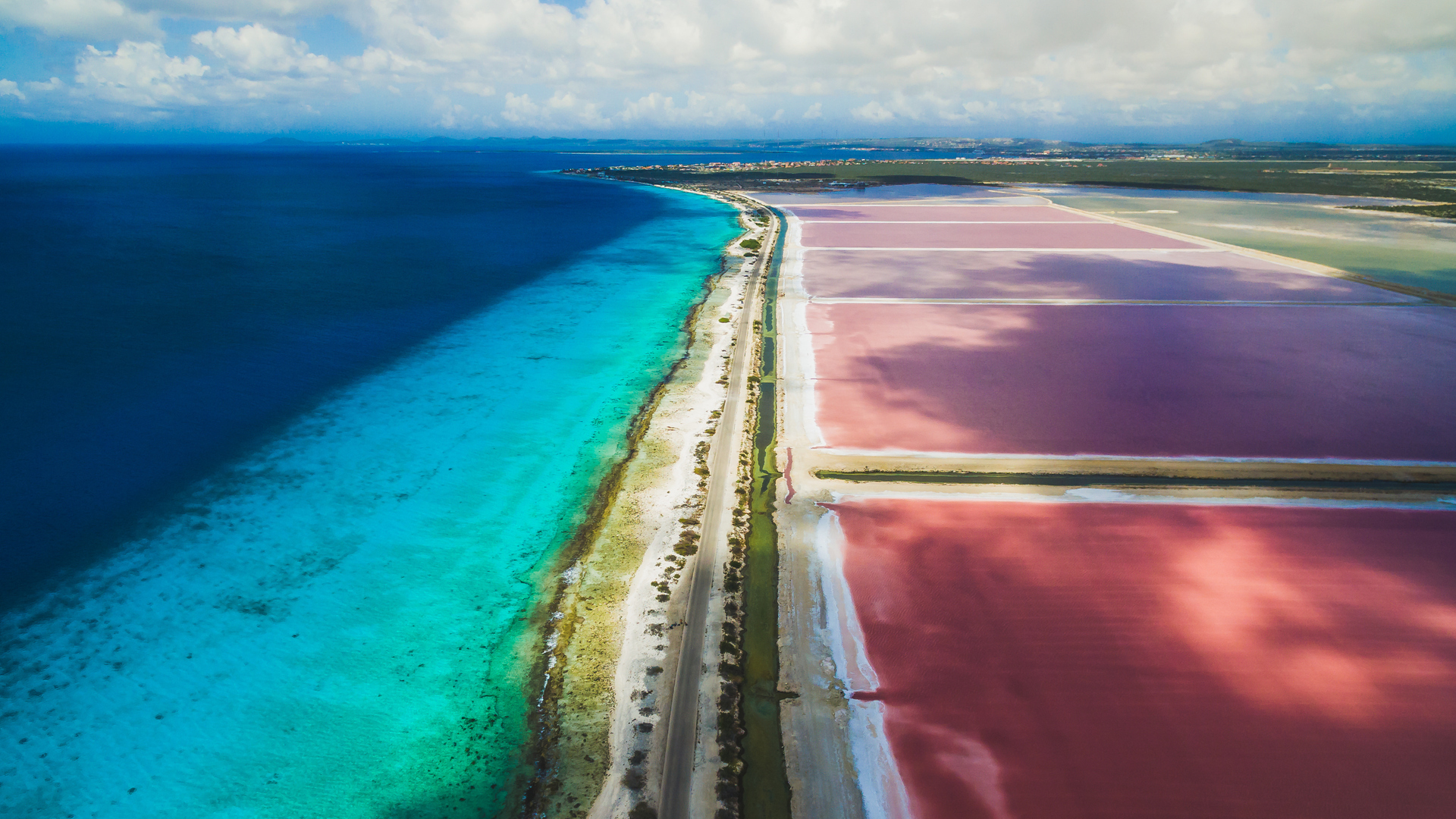 Vía que separa el agua rosada salina con las aguas turquesa