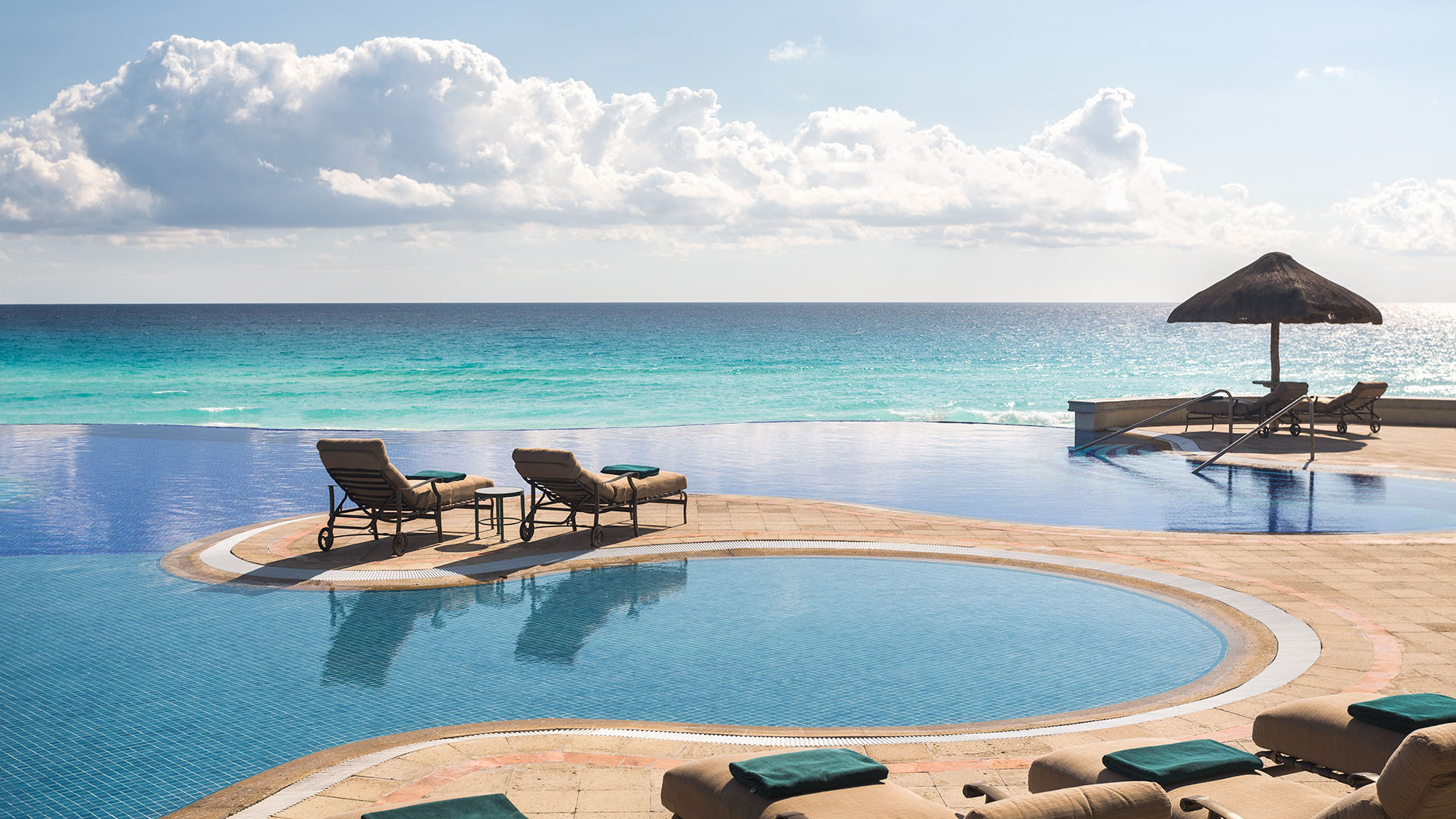Sillas en la piscina con vista al mar Caribe