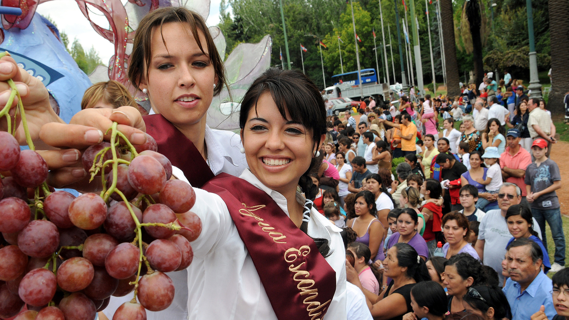 Mujeres mostrando la cosecha de uvas