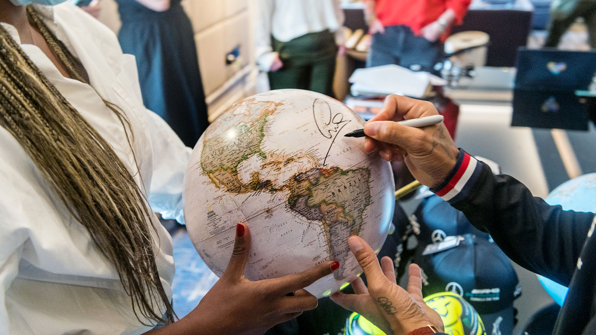 Lewis Hamilton firmando un autógrafo