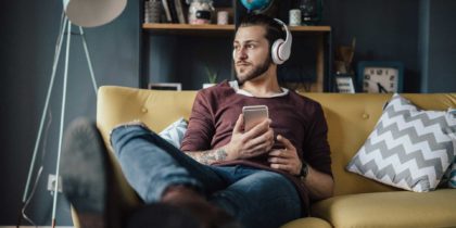 man listening to podcast on couch