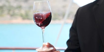 man swirling glass of red wine to taste