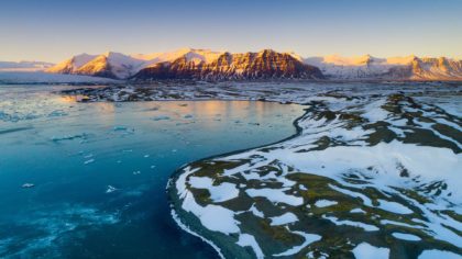 View of icy waters and snowcapped mountain in Vatnajökull National Park.