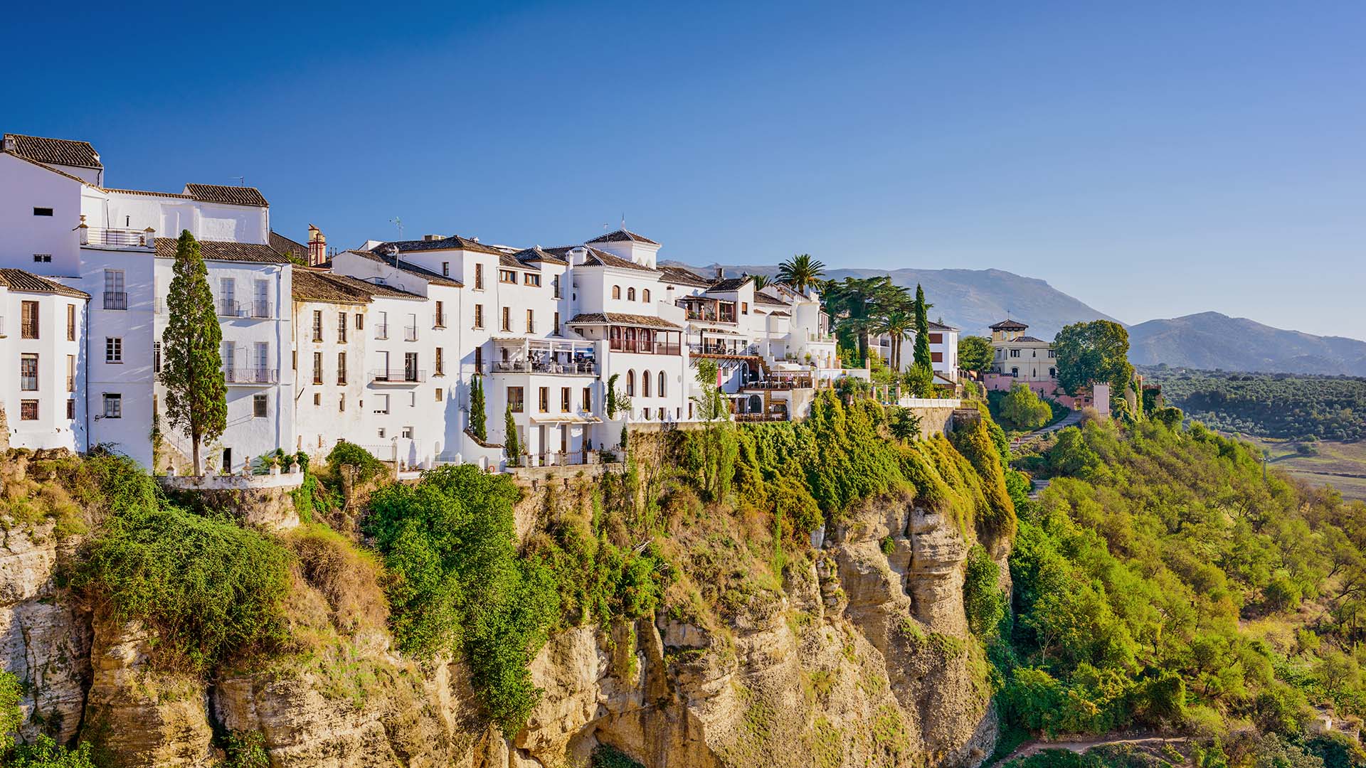 Cliffside view of Ronda, Spain, dotted with white houses.