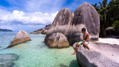 sitting on rocks over water in anse source de argent