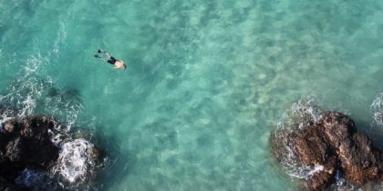 a lone man snorkels at hapuna beach hawaii