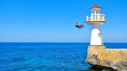 man diving from lighthouse