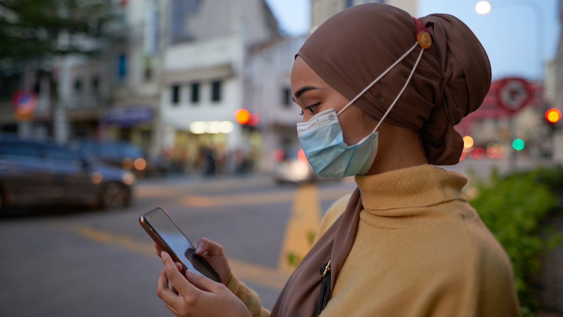 woman in face mask using ride share