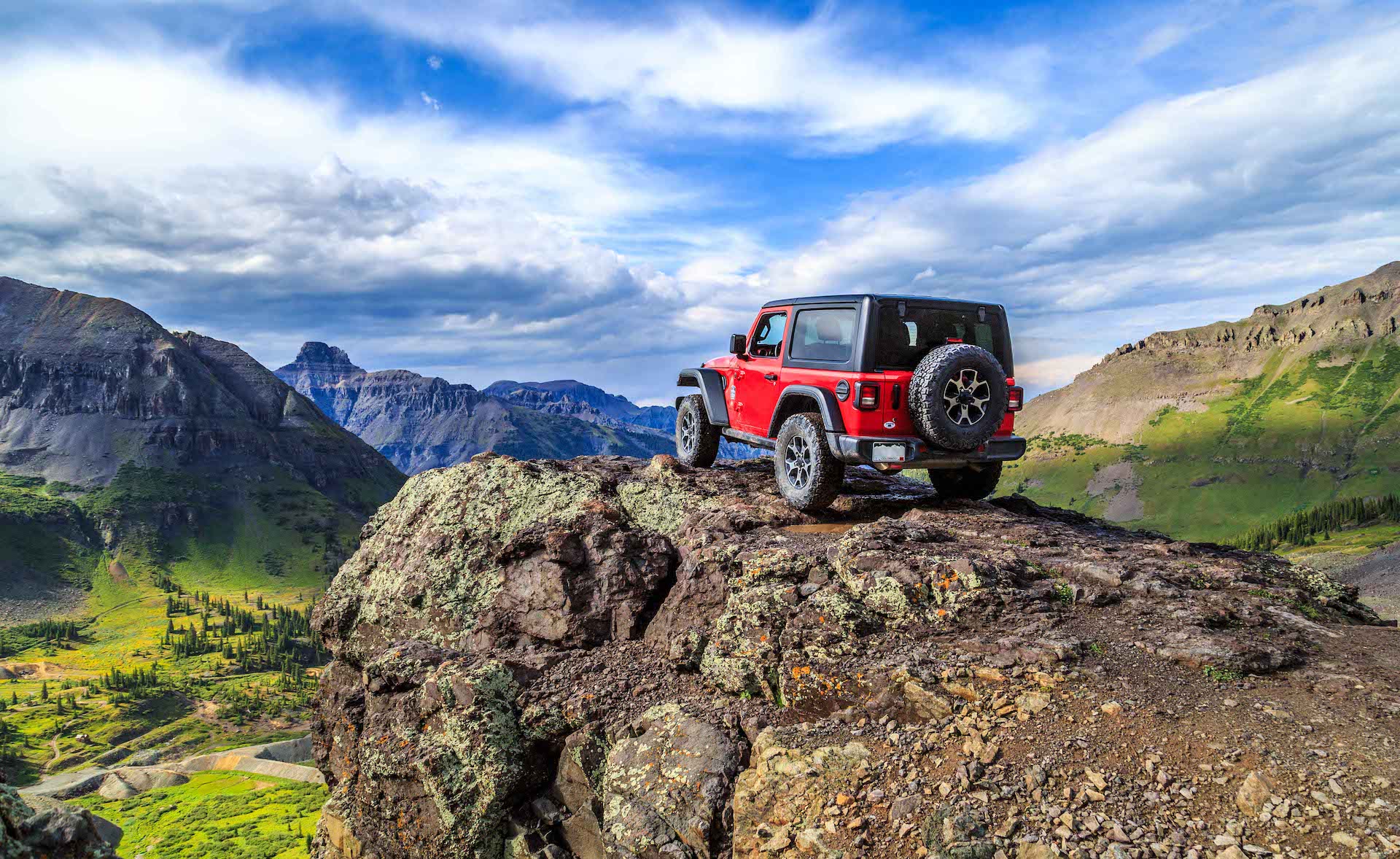 Red jeep on overlook in Rocky Mountains