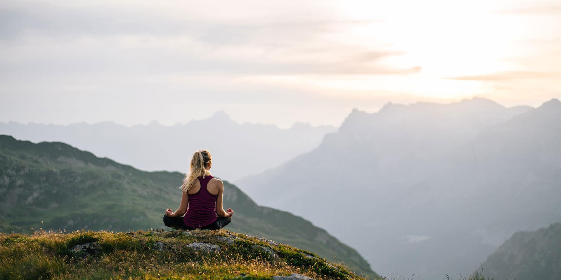 woman meditating overlooking mountains