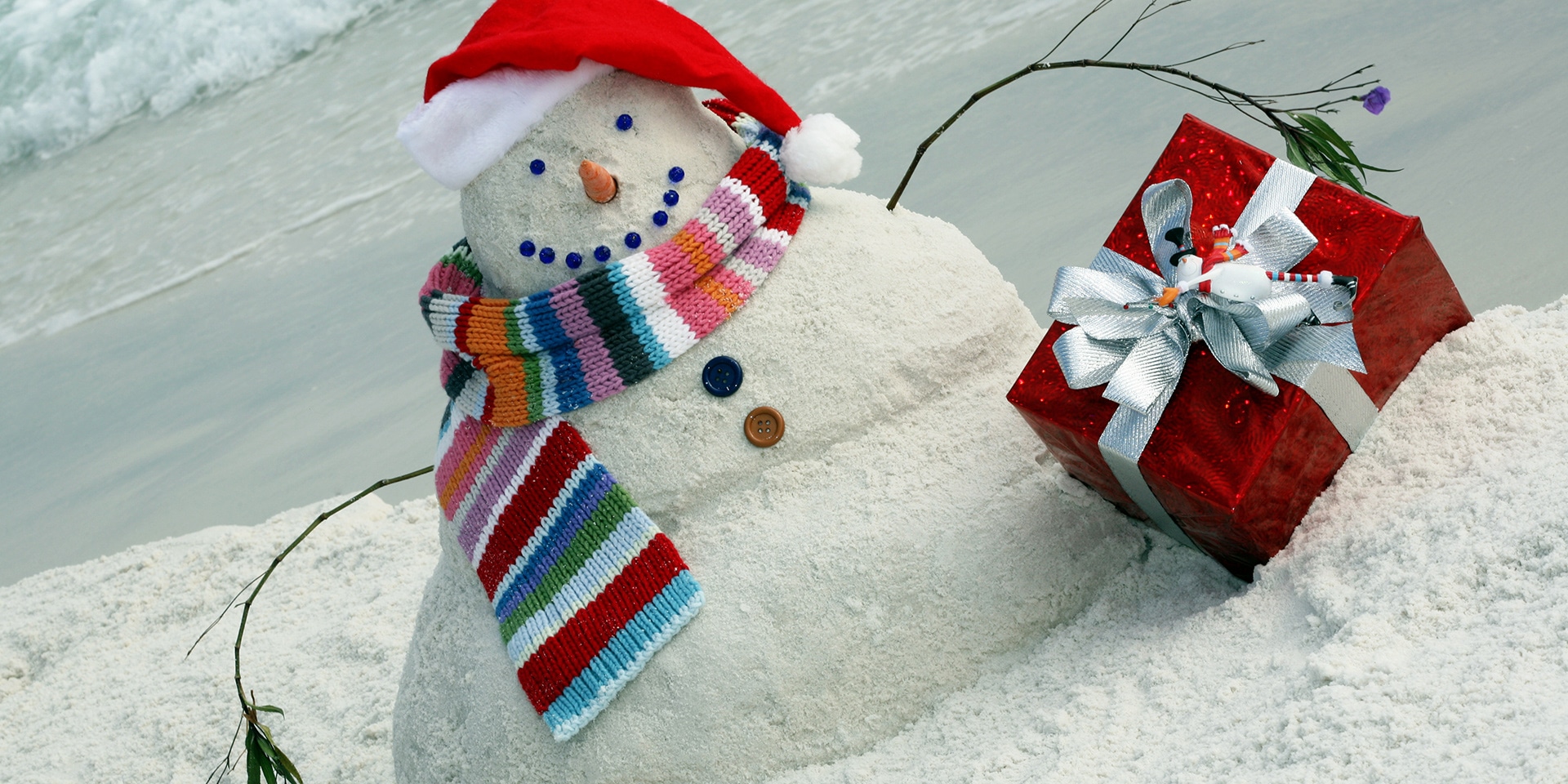 snowman made of sand dressed like santa