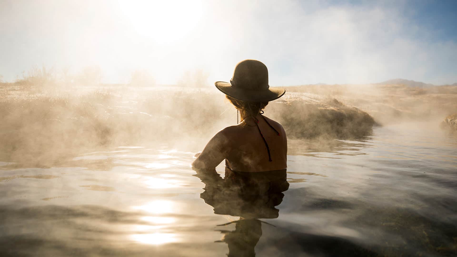 woman in hat in swimming in thermal springs