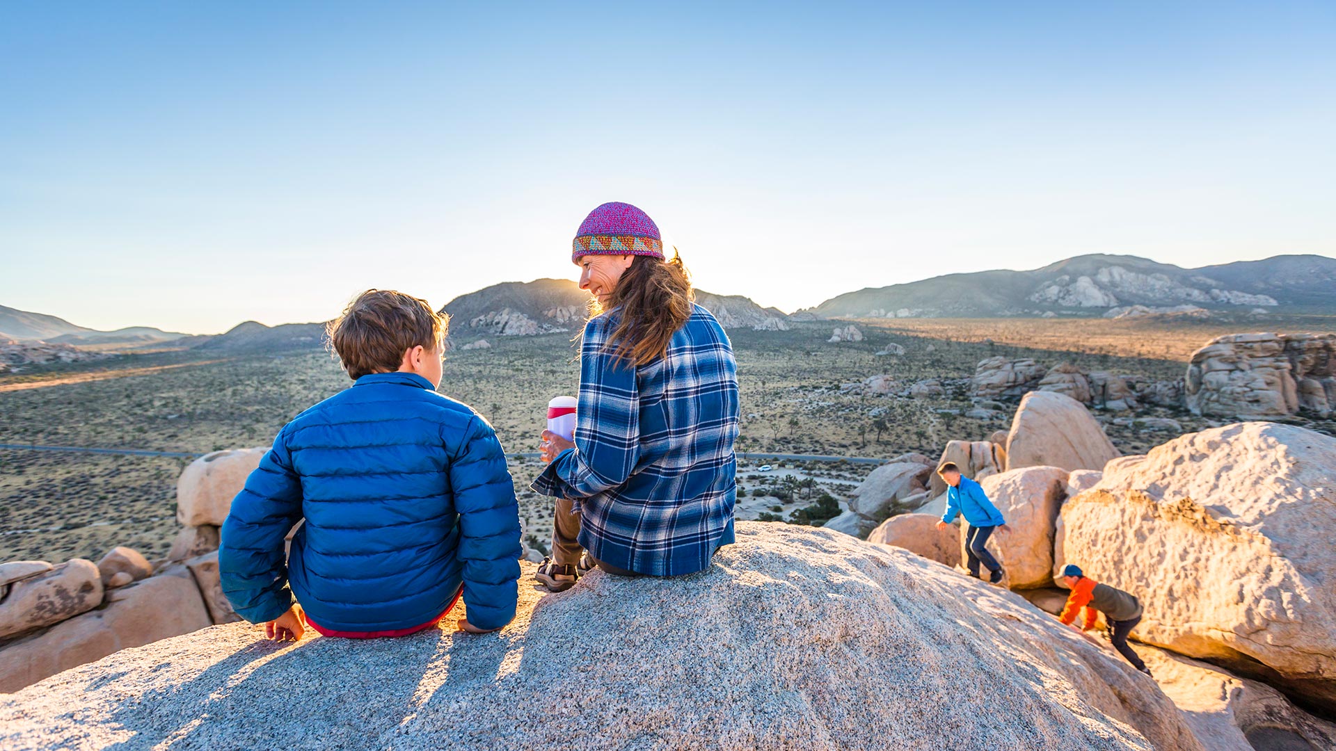 mother and children on rock overlooking joshua tree national park