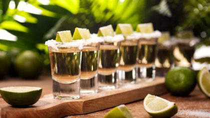 shot glasses of mezcal with limes