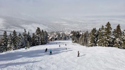 people skiing down a mountain slope in utah