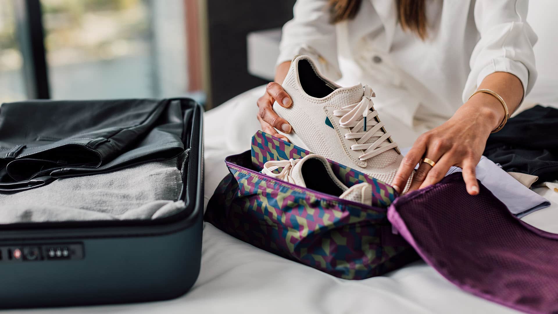 woman packing sneakers into bag