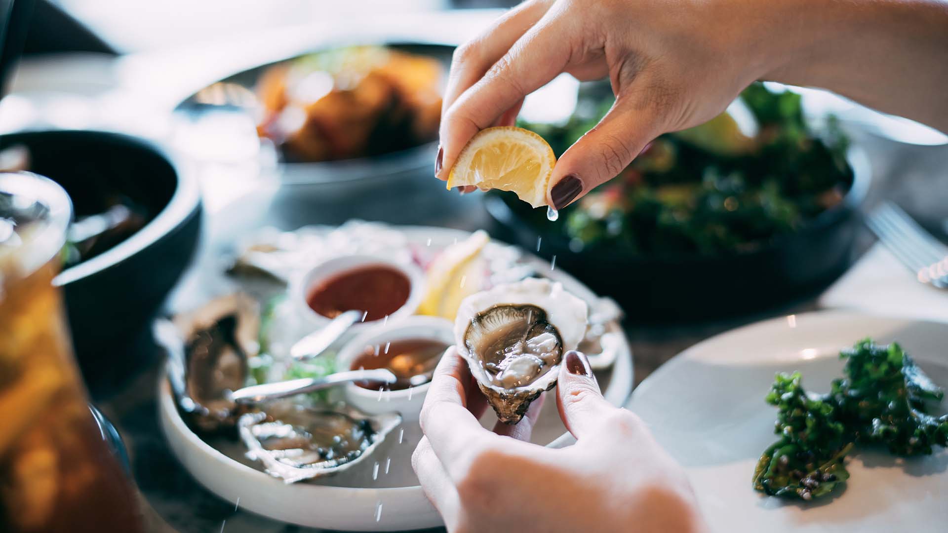 squeezing lemon on oyster