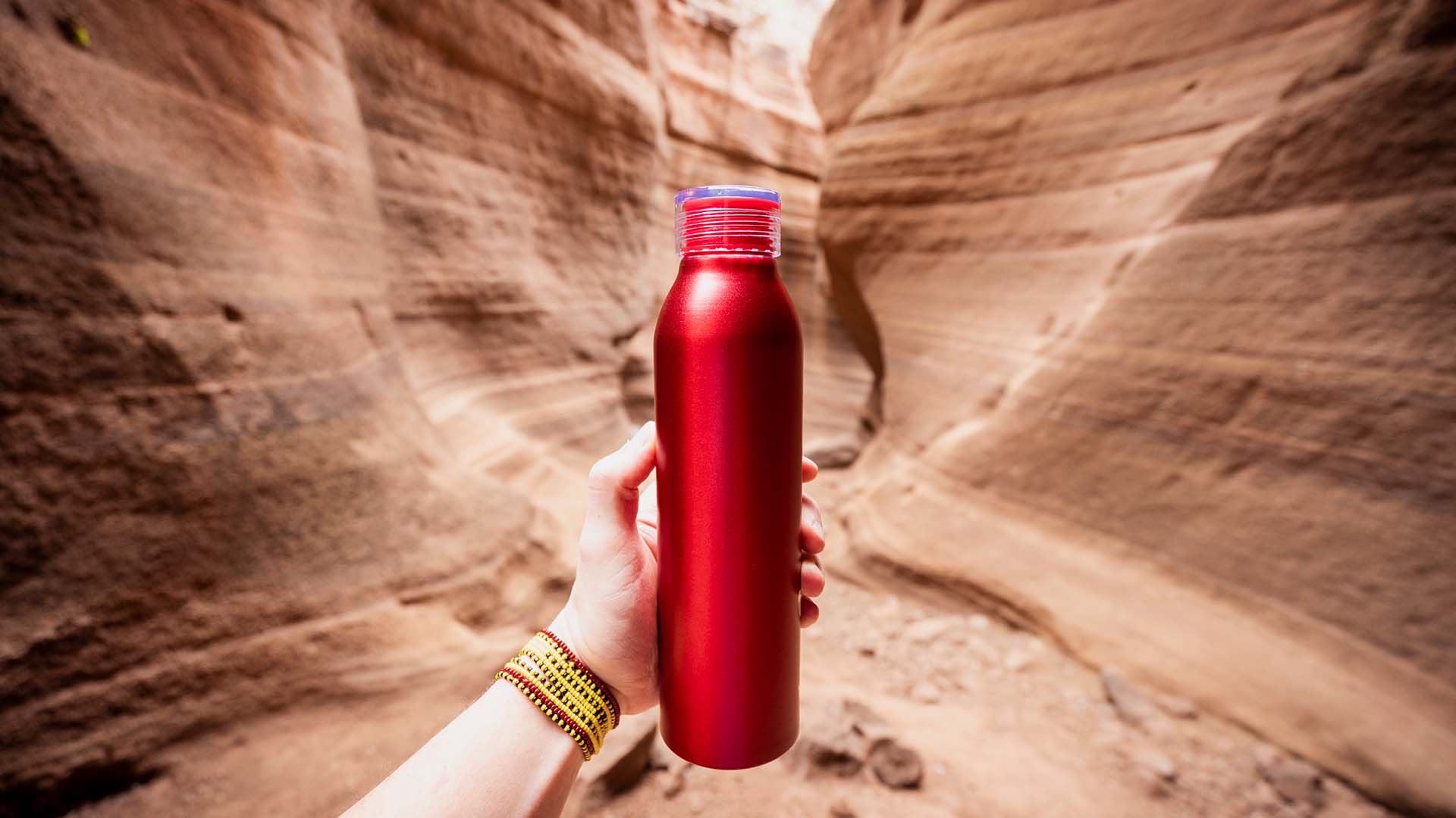 red water bottle in front of canyon