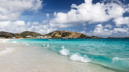 White sand beach in St. Martin with mountains in distance