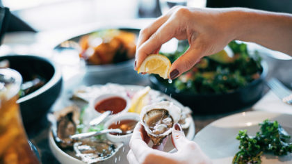 Squeezing lemons over oysters.