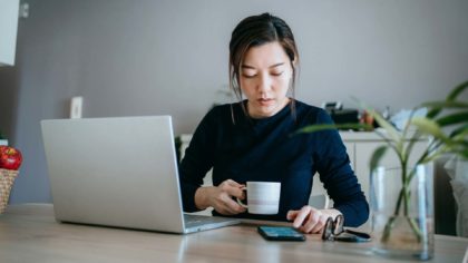 Woman with computer, phone, and cup of coffee