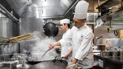 Chefs at Run Hong Kong cooking in the kitchen on steamy woks.