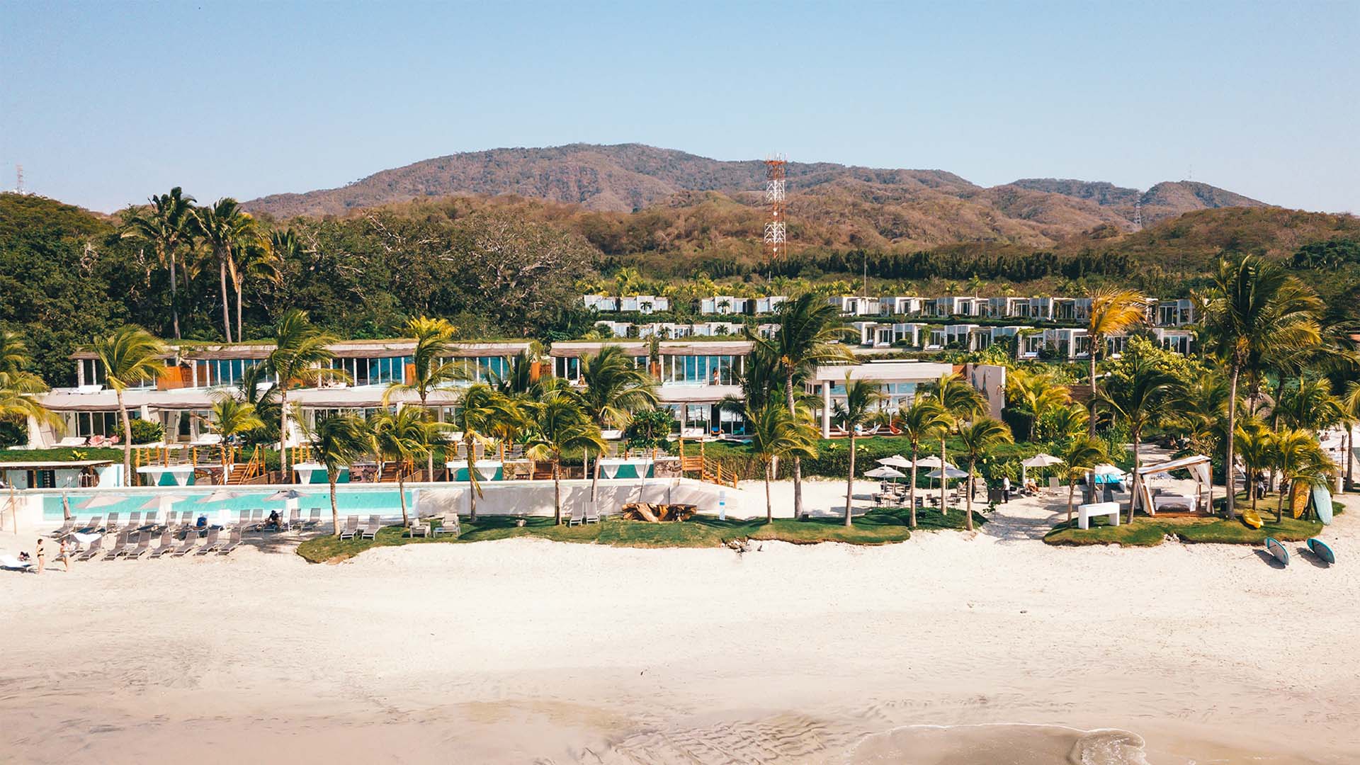The St. Regis Punta Mita Resort from a beachfront view with mountains in the background