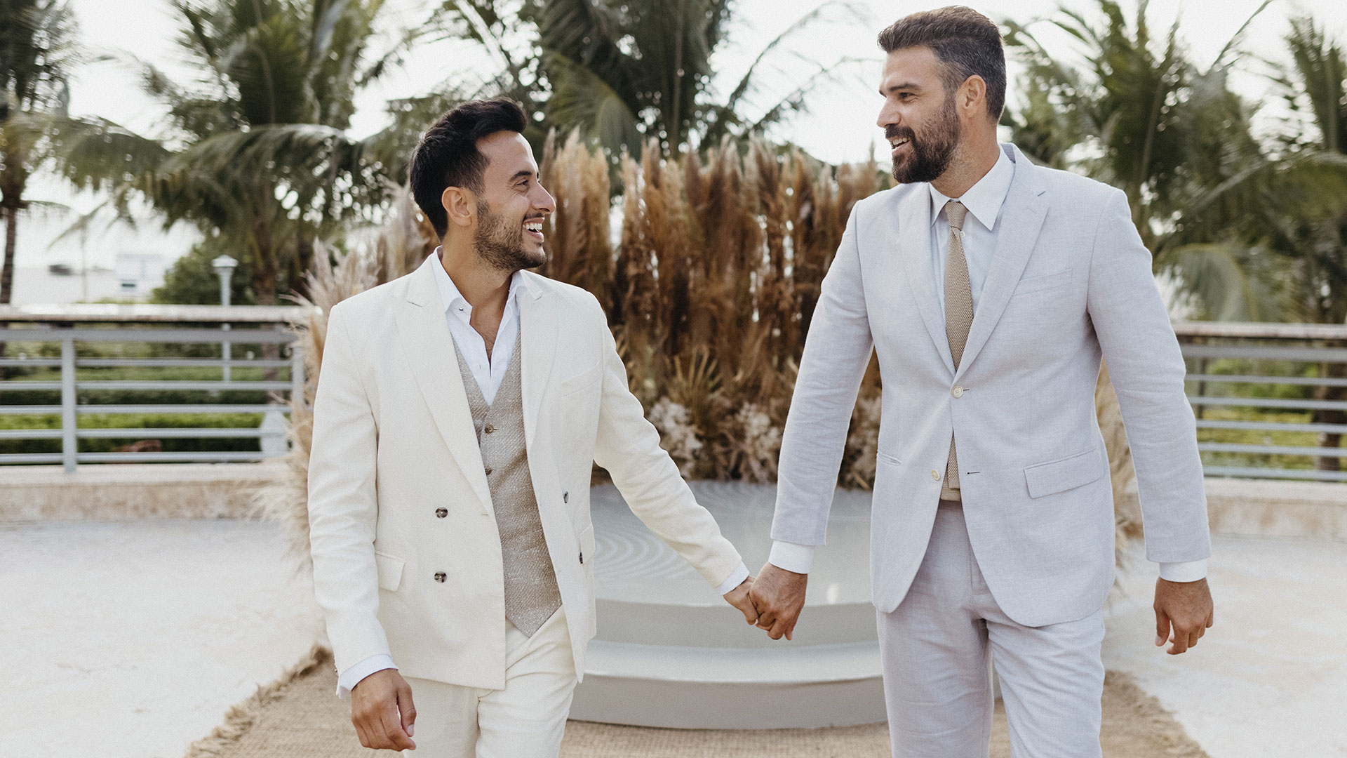 Two men walking down the aisle in white suits at the Ritz Carlton South Beach