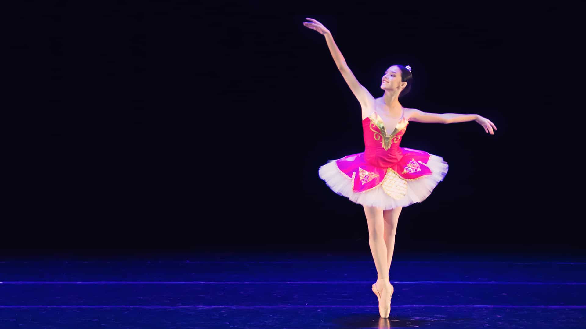 Ballerina dancing onstage on pointe in tutu