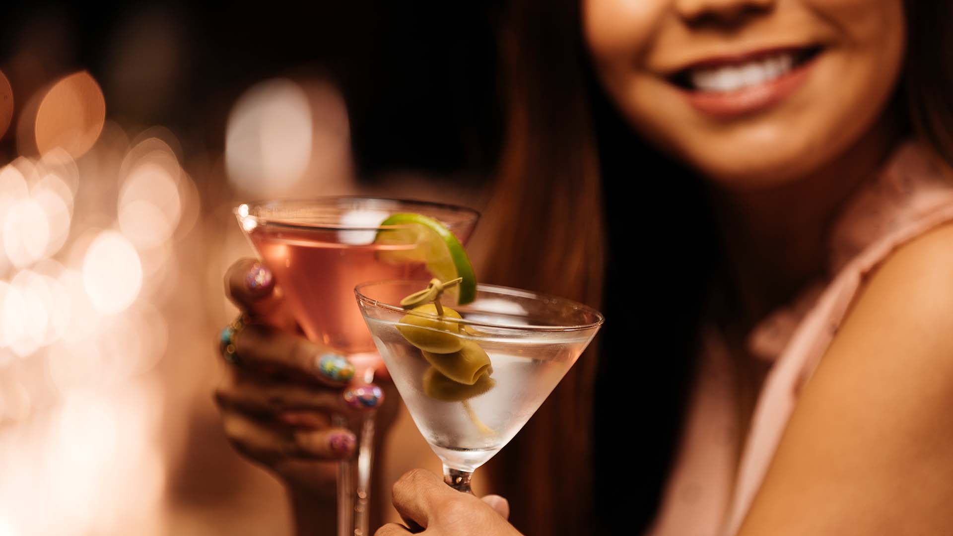 woman smiling and toasting cocktails