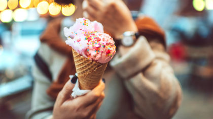 Pink ice cream with sprinkles in a cone
