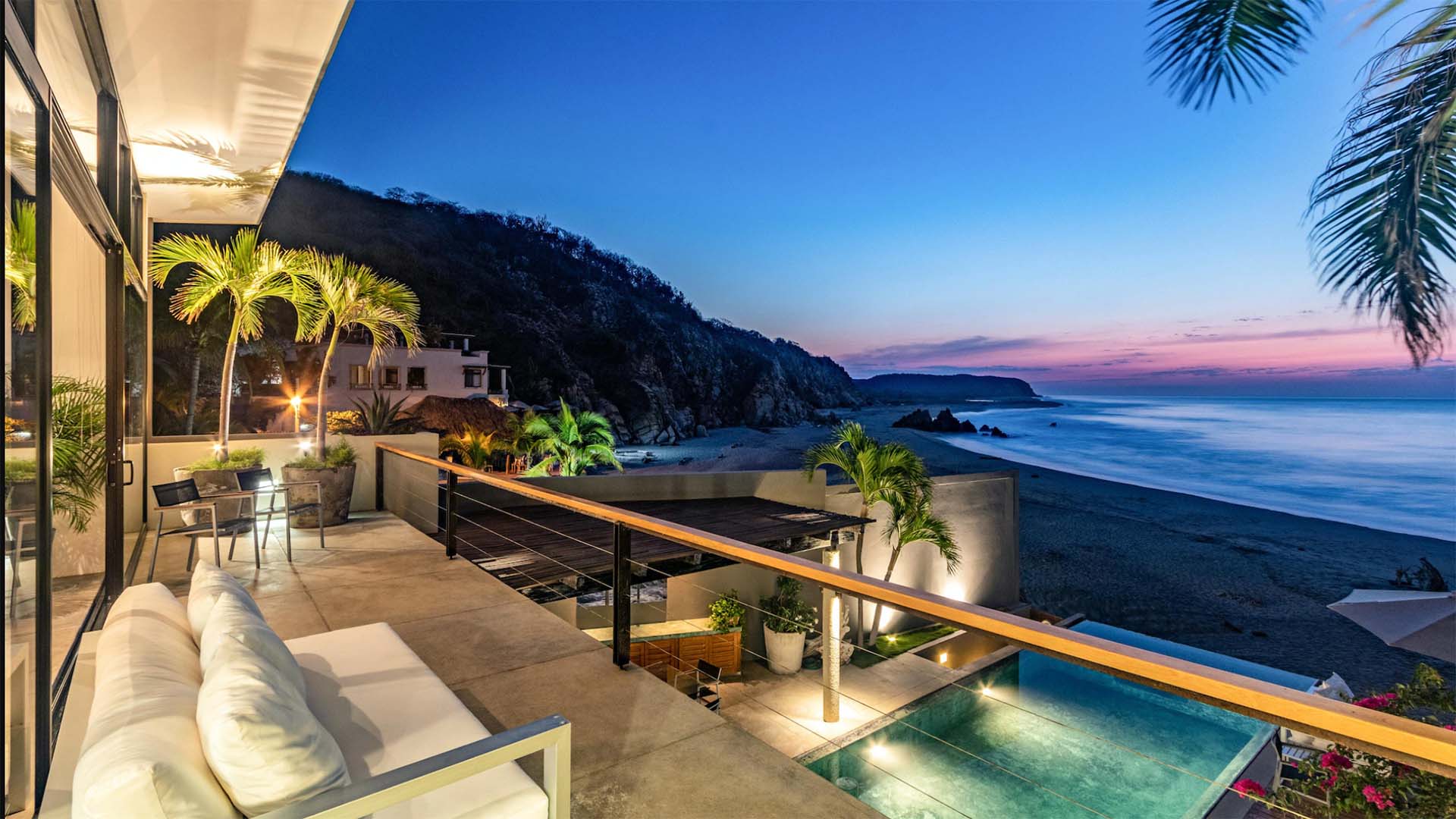 beachfront villa at dusk with pool