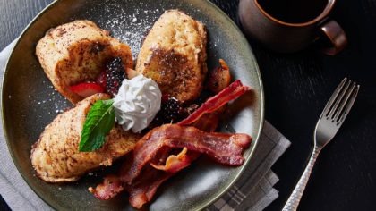 Breakfast plate with French toast bacon and berries