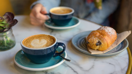 Latte in cup and chocolate croissant
