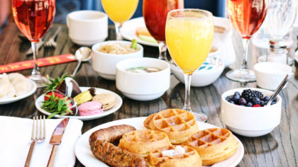 Waffles and mimosas with berries and sausage