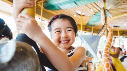Child smiling while riding carousel