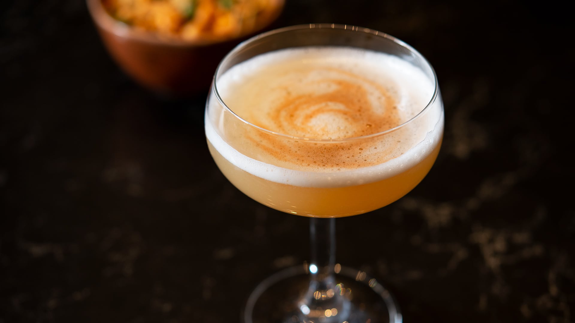 Frothy cocktail in a tasting glass