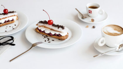 Coffee and eclair with cherry