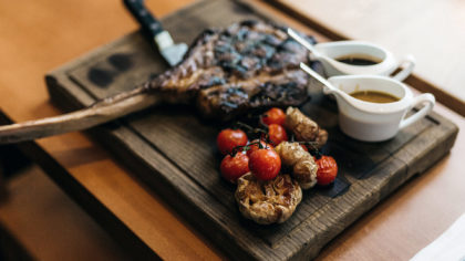 Steak and vegetables on wood plank