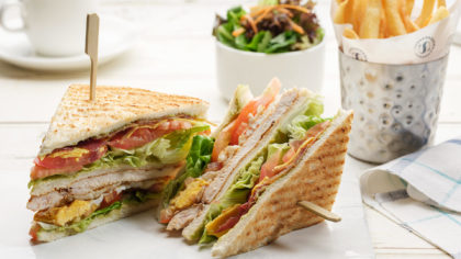 Club sandwich with fries and a salad