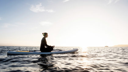 Person on a paddle board meditating