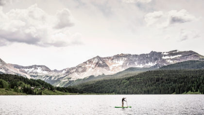 Paddleboarder on Trout Lake with mountains in background