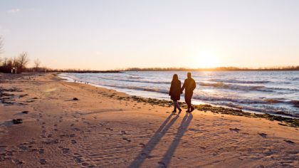 Couple walking down beach at Toronto Island