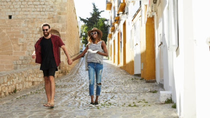 couple walking cobblestone street in ibiza