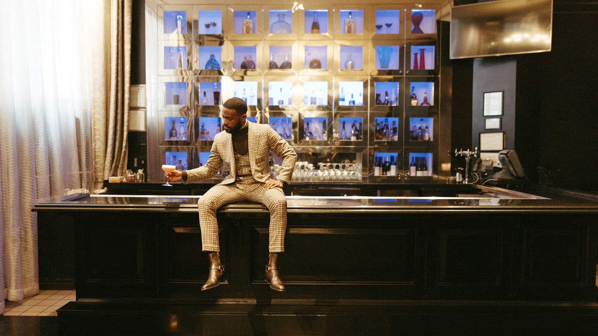man sitting on bar with cocktail