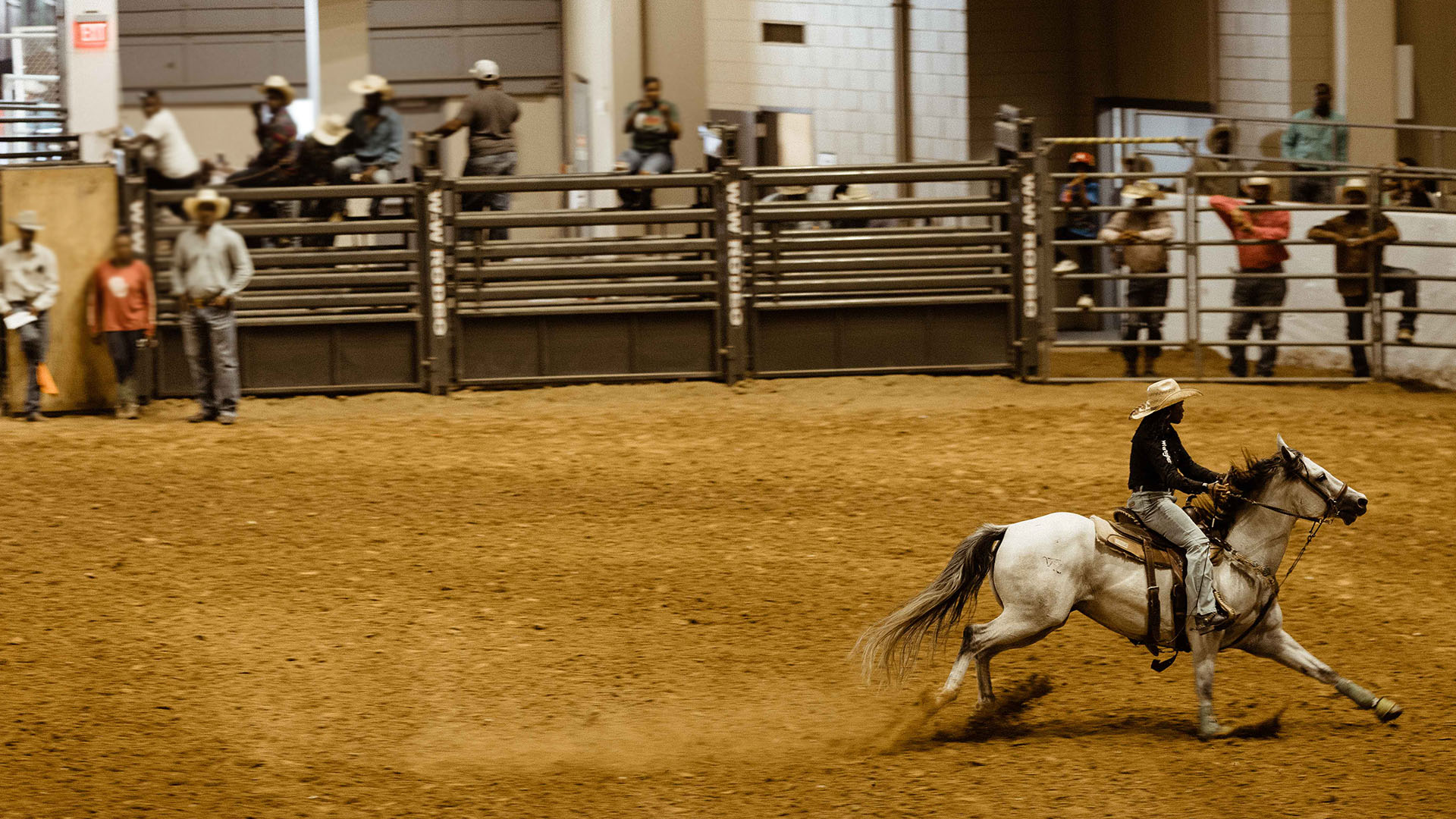 A cowboy riding a horse at a rodeo 
