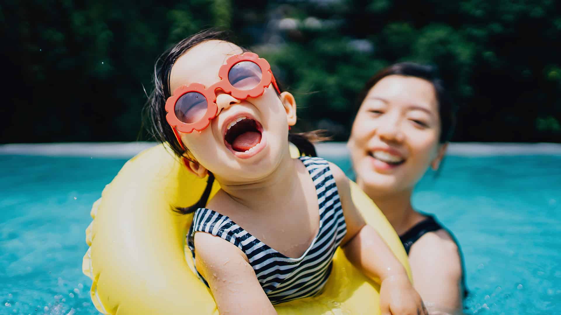 mother and toddler with sunglasses in pool