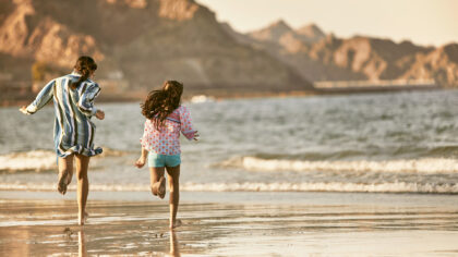 kids on beach at Al Bustan Palace, A Ritz-Carlton Hotel