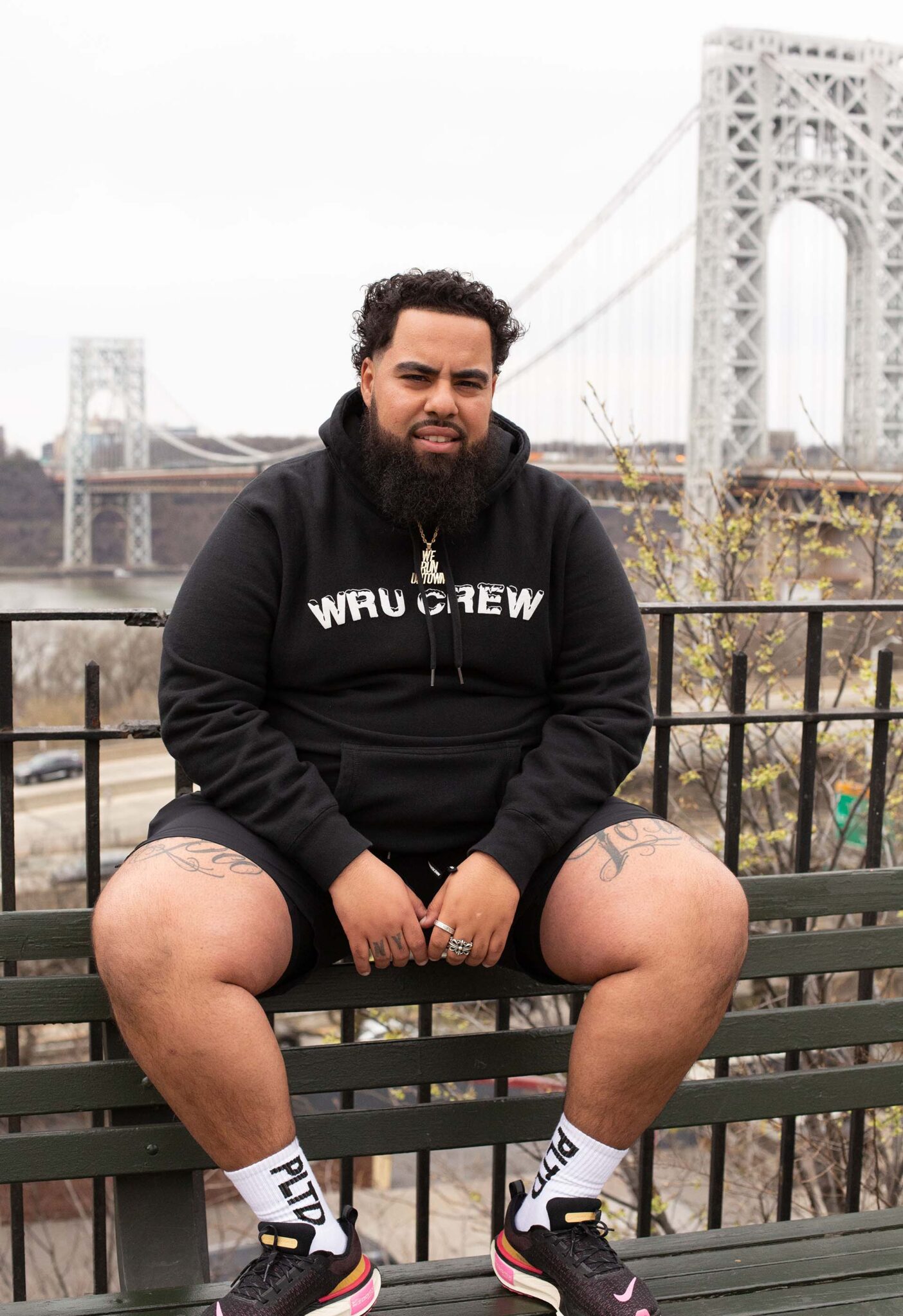 Hector Espinal of We Run Uptown posing in front of the George Washington Bridge in Manhattan