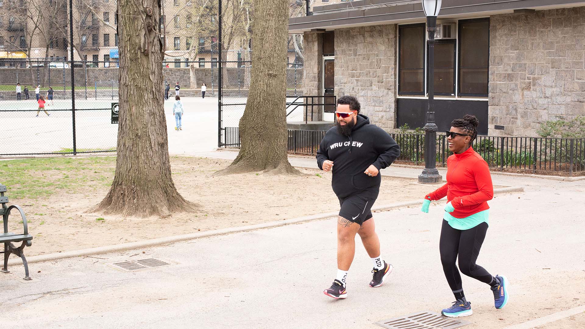 About the Journey podcast host Oneika Raymond and We Run Uptown founder Hector Espinal run in a park in Washington Heights